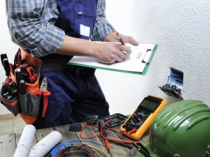 Young electrician estimating in a residential electrical installation